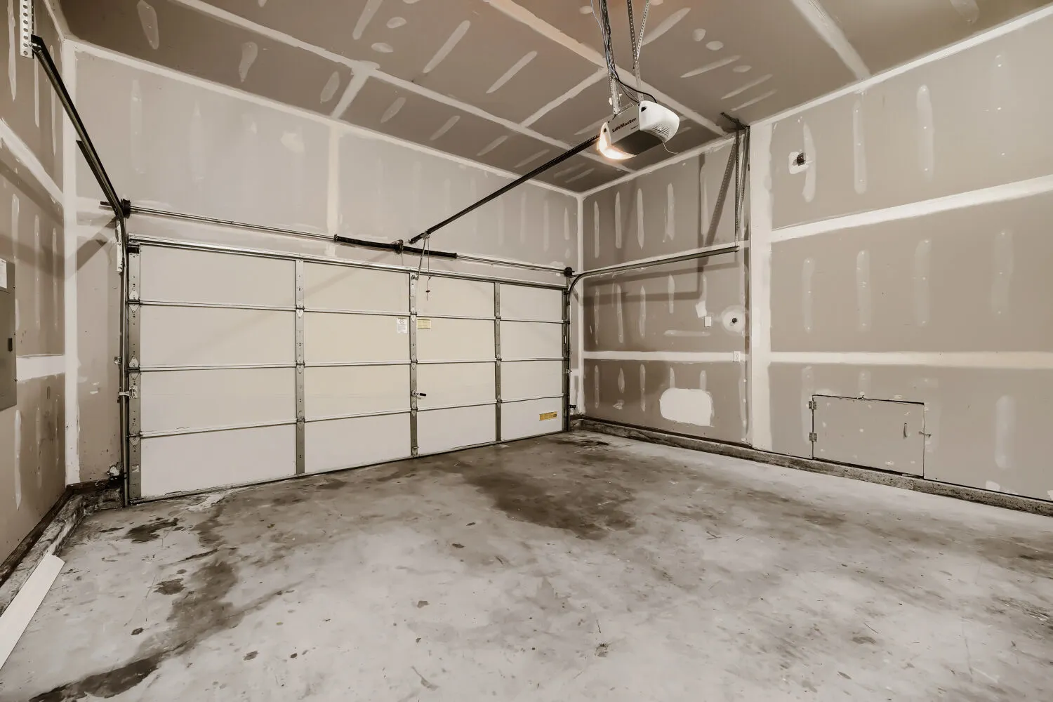 Inside the attached two car garage with vaulted ceiling