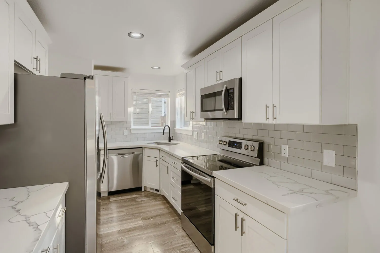Kitchen with white cabinetry and quartz counters